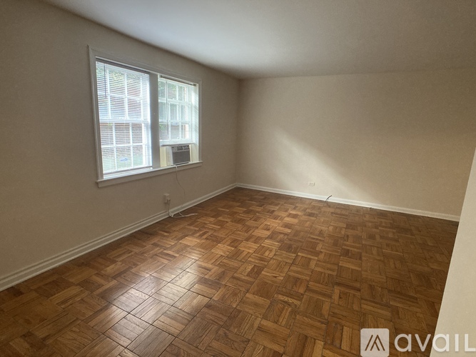 A room with wooden flooring and a window.