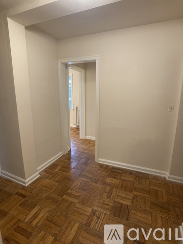 A hallway with a wooden floor and white walls.