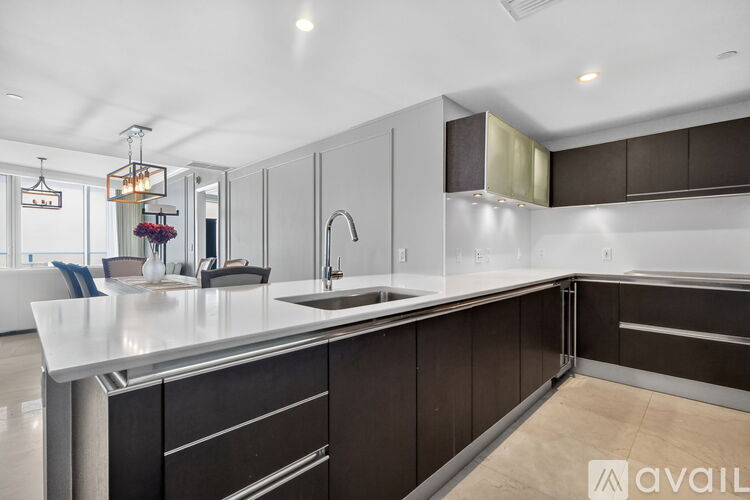 A modern kitchen with dark brown cabinets and a white countertop.