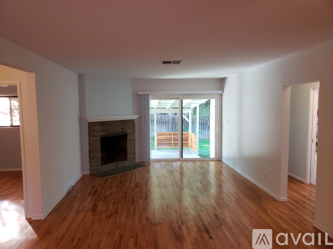 A living room with a fireplace and sliding glass doors leading to a deck.