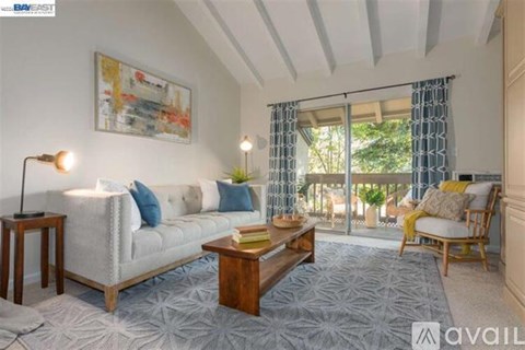 A living room with a grey sofa, a wooden coffee table, and a painting on the wall.