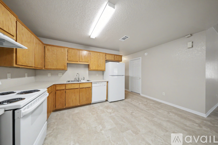 A kitchen with wooden cabinets and a white stove top oven.