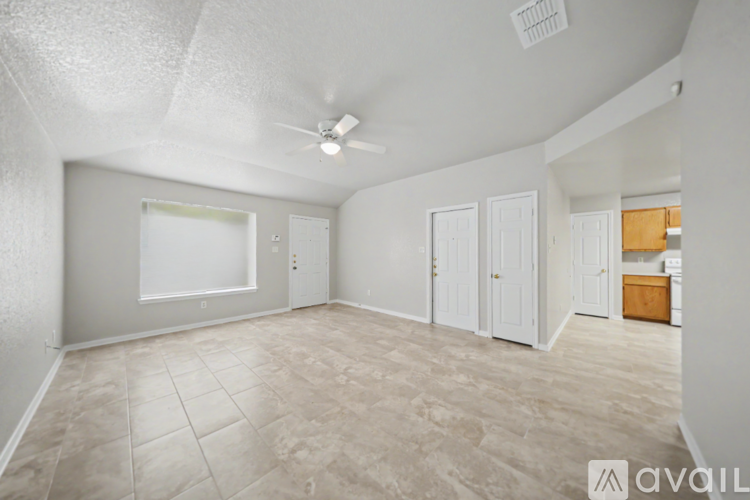A spacious room with a fan and a window.