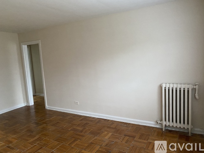 A room with a wooden floor and a white radiator.