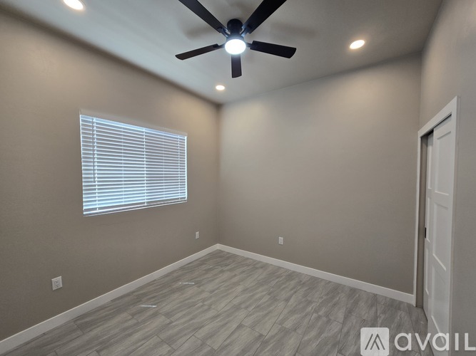 A spacious hallway with tiled flooring and a doorway leading to a balcony.