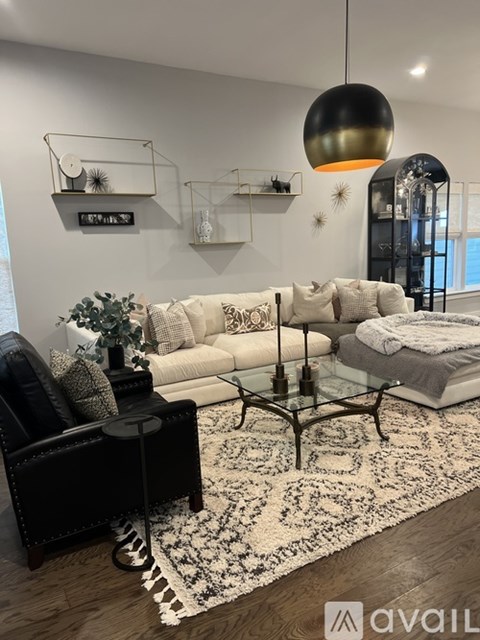 A modern living room with a black leather chair and a white sofa.