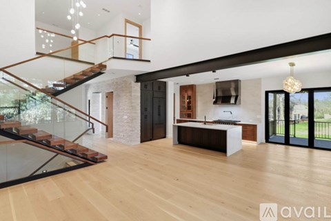 A modern interior with a wooden floor and a glass staircase.