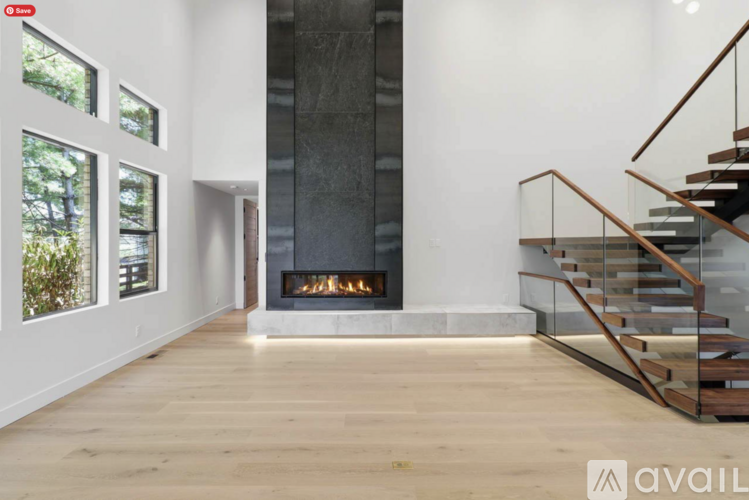 A modern living room with a fireplace and a staircase.