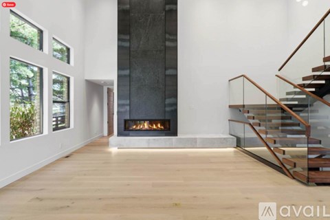 A modern living room with a fireplace and a staircase.