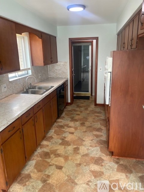 A kitchen with brown cabinets and a checkered floor.