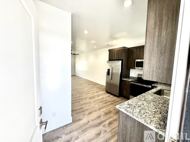 A kitchen with a refrigerator, microwave, and oven.