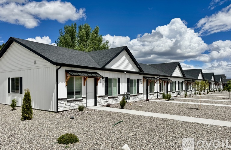 A row of houses with gravel driveways in front.