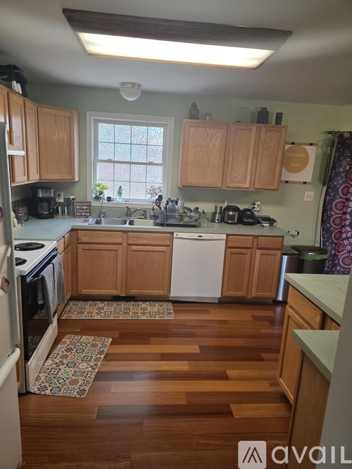 A kitchen with wooden cabinets and a white dishwasher.