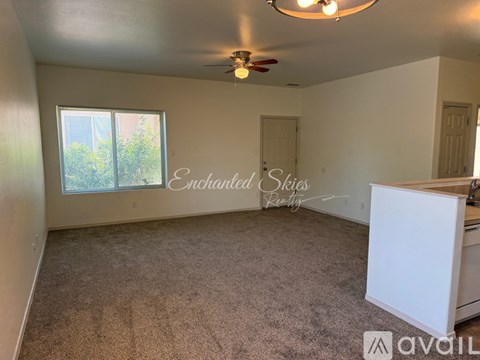 A room with a carpeted floor and a ceiling fan.