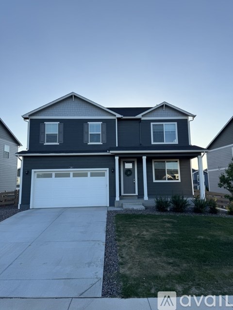A two-story house with a garage and a driveway.
