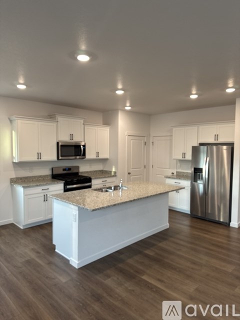 A kitchen with white cabinets and a granite countertop.