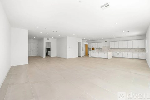 A spacious, empty room with white walls and a tiled floor.