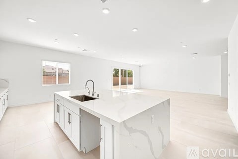 A modern kitchen with a large island and wooden floors.