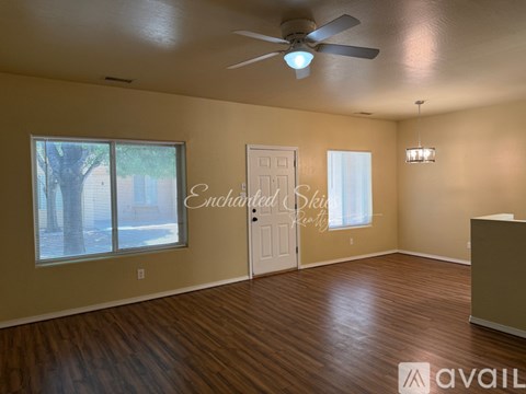 Empty room with a ceiling fan and wooden flooring.