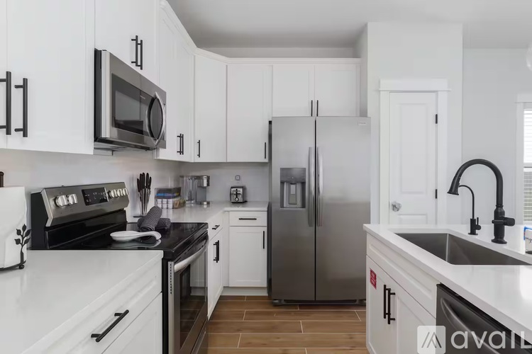 A kitchen with white cabinets and a black stove top.