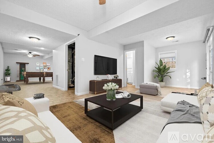 A living room with a black coffee table and a flat screen TV.