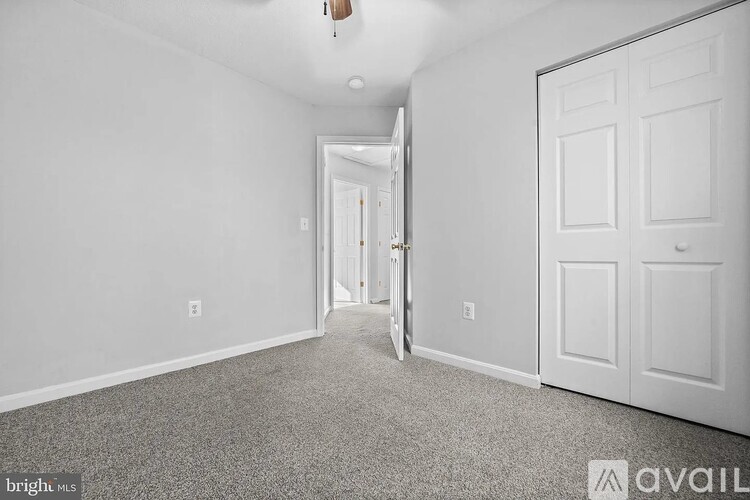 A spacious room with a carpeted floor and white walls.