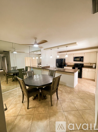 A kitchen with a table and chairs in the foreground.