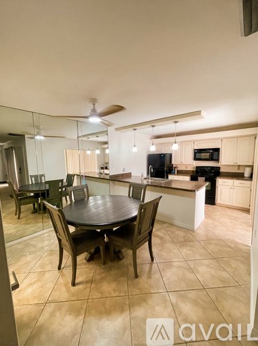A kitchen with a table and chairs in the foreground.