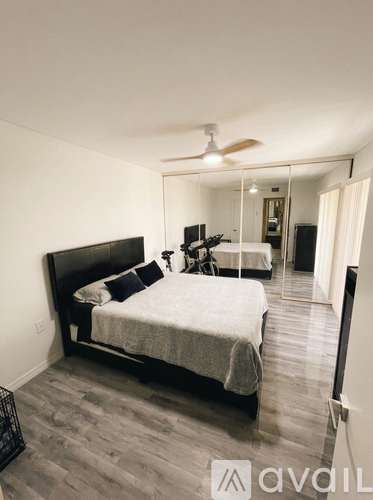 A bedroom with a large bed and a ceiling fan.