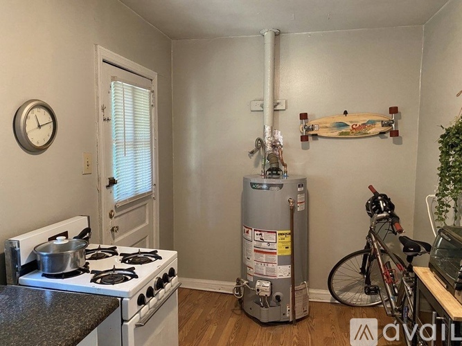 A small kitchen with a stove and a water heater.