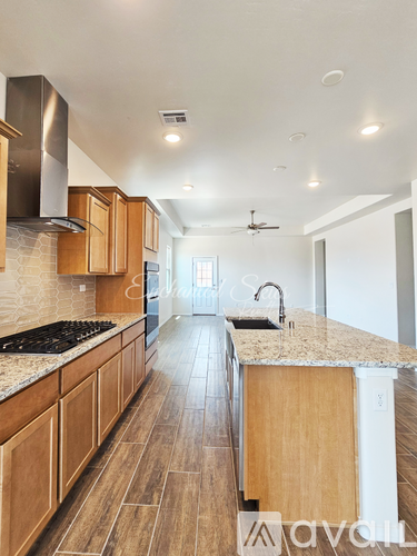 A kitchen with wooden cabinets and a marble countertop.