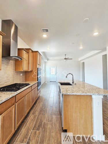 A kitchen with wooden cabinets and a marble countertop.