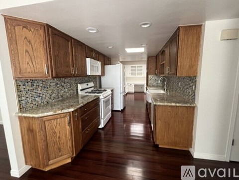 A kitchen with wooden cabinets and a tiled backsplash.