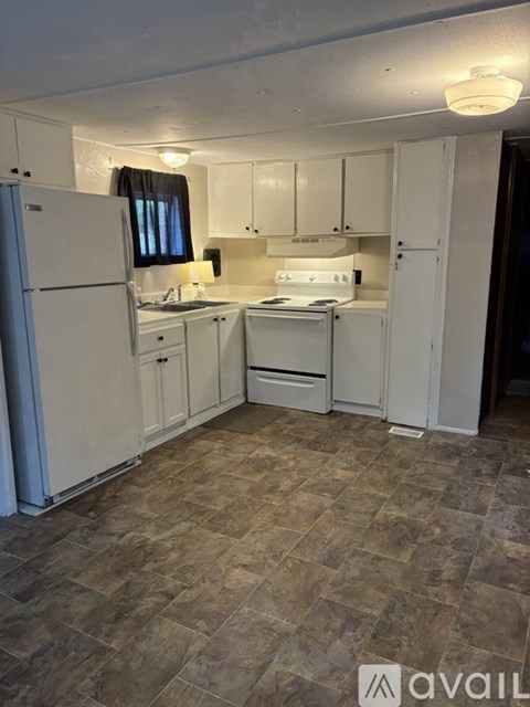 A kitchen with white appliances and cabinets.