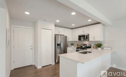 A modern kitchen with white cabinets and appliances.