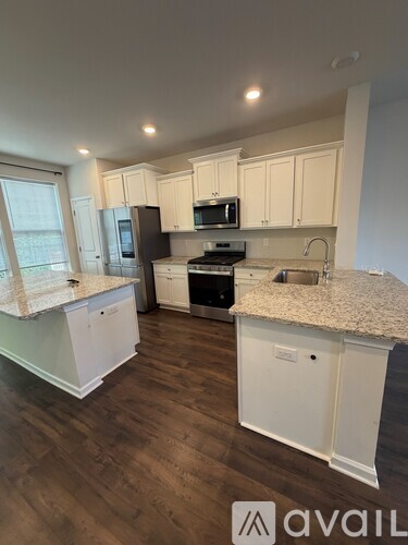 A kitchen with white cabinets and a granite countertop.