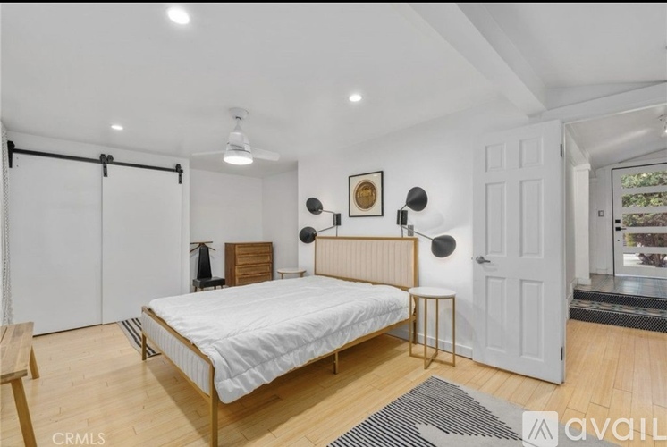 A bedroom with a bed, a chair, and a small table.