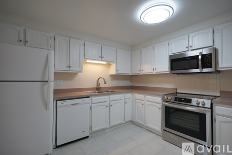 A kitchen with white cabinets and appliances.