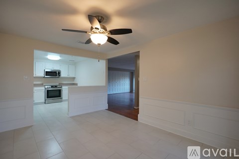 A spacious kitchen with a fan and a microwave above the oven.
