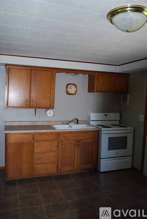 A kitchen with wooden cabinets and a white stove.