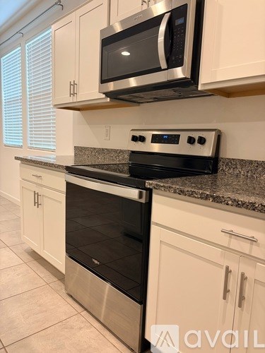 A kitchen with a stove and microwave above it.