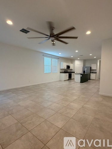 A spacious room with a ceiling fan and tiled flooring.