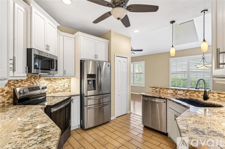A kitchen with a black stove top oven and a black microwave.