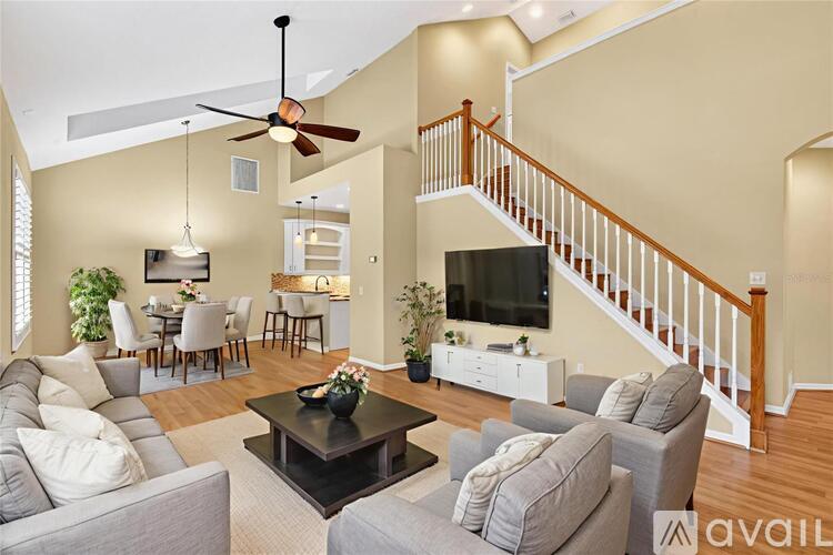 A living room with a staircase and a television.