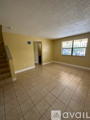 A room with a tiled floor and a window with bars on it.