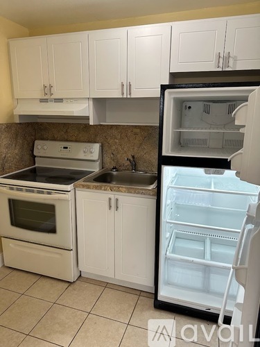 A kitchen with a white refrigerator, oven, and sink.