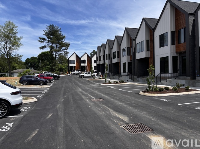 A row of houses with cars parked in front.