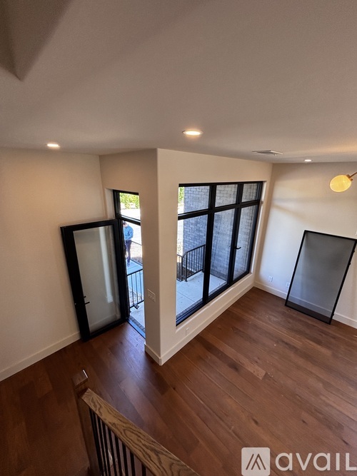 A room with wooden floors and a large window.