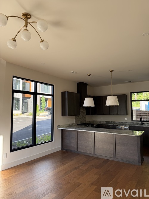 A modern kitchen with dark wood cabinets and a large island.