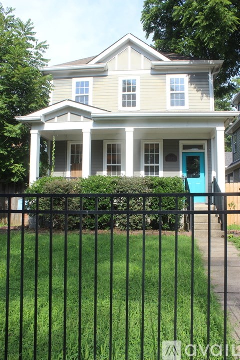 A house with a blue door and a black fence.